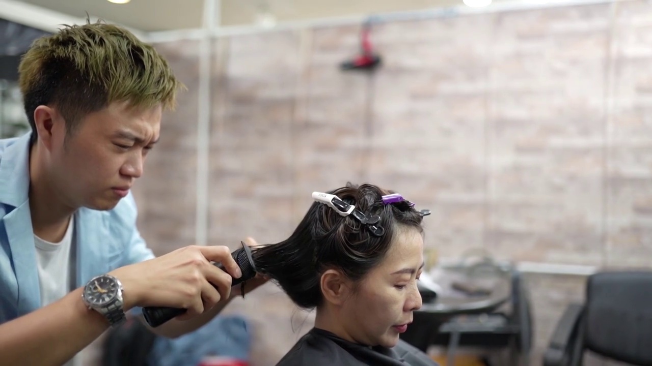 亚洲华人美发师在美发厅使用理发器刮胡子。理发店。视频素材