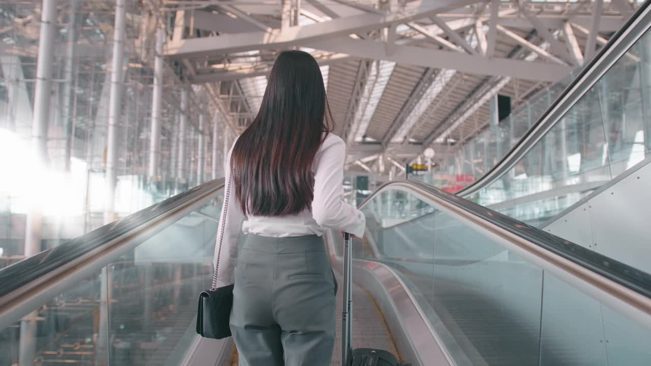 一名商务女性在国际机场戴着防护口罩，在新冠肺炎疫情下旅行，安全旅行，社交距离礼仪，新常态旅行理念视频下载