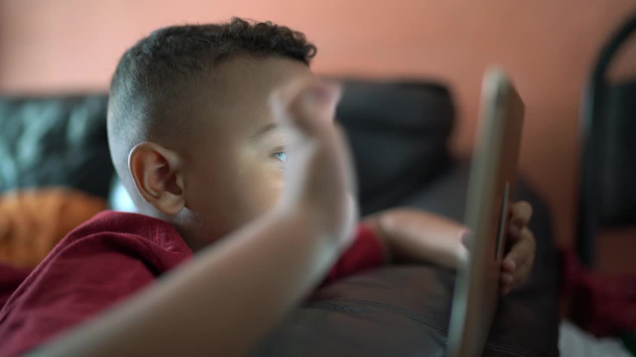 男孩在家里用平板电脑看东西视频下载