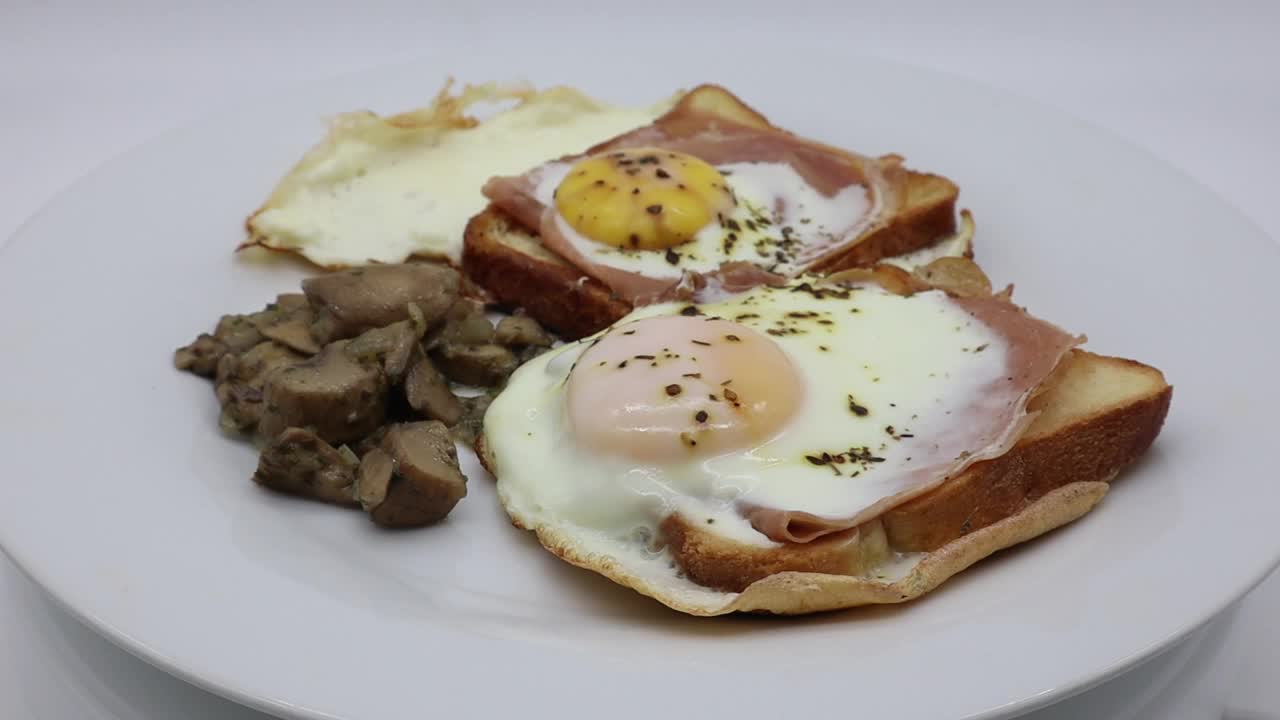 鸡蛋，火腿，奶酪，面包和蘑菇放在一个白色的旋转盘子里视频素材