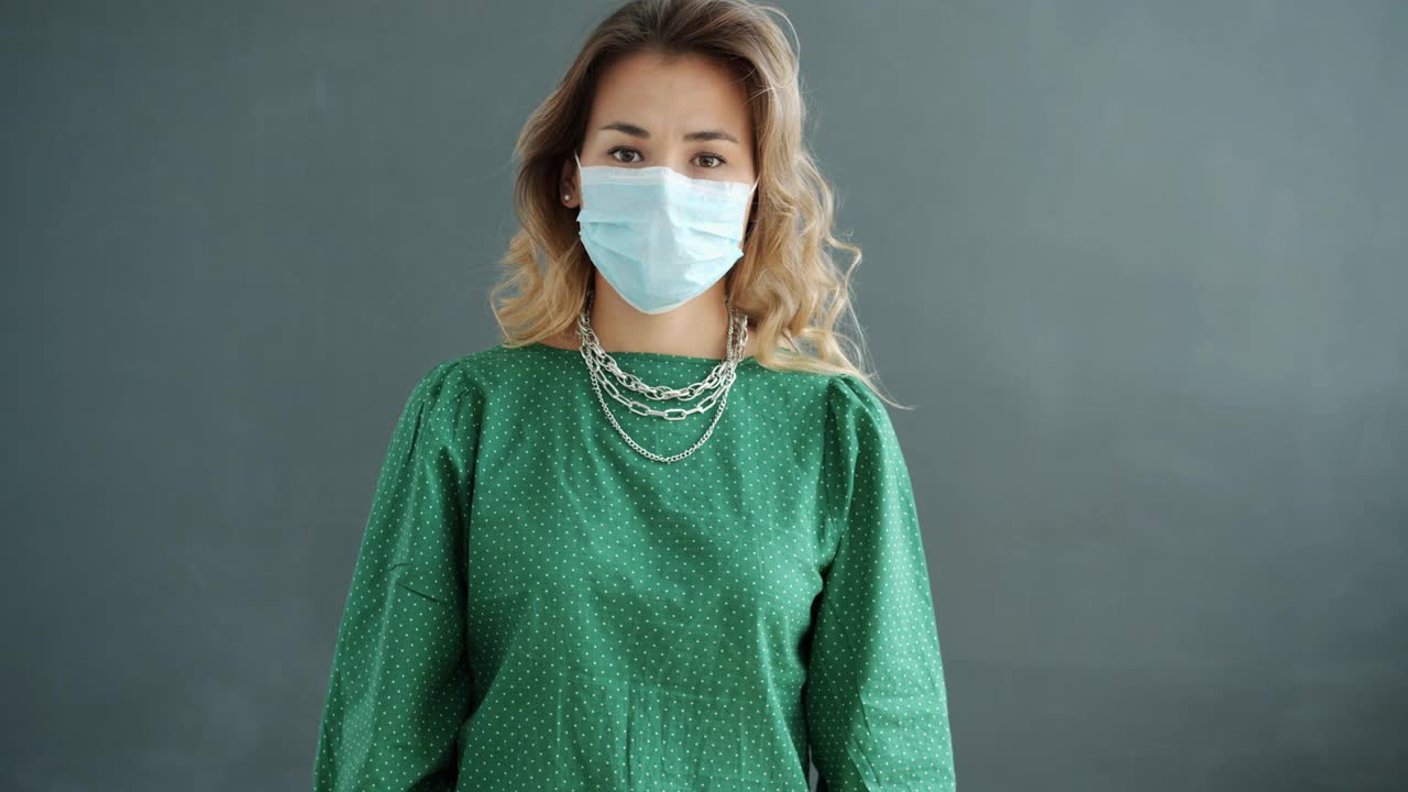 年轻女子戴医用口罩的慢动作表示反对和拒绝视频素材