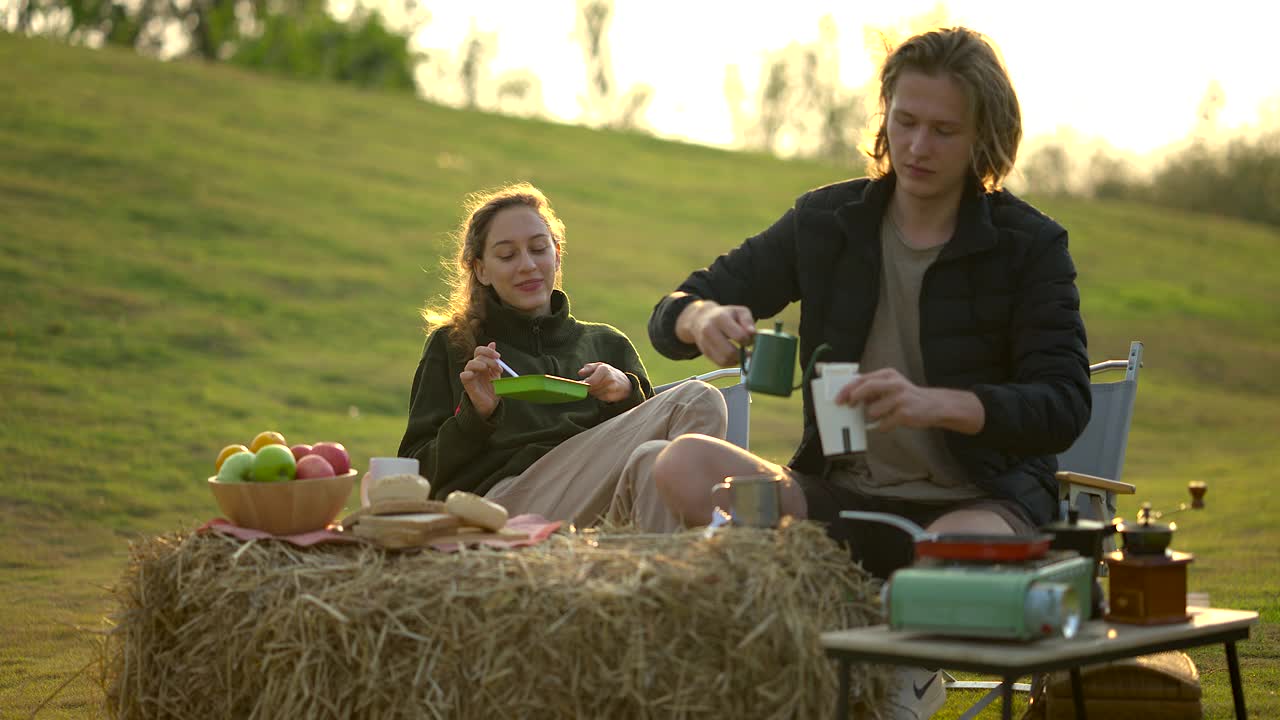 一对夫妇在露营公园一起吃早餐和放松的时间视频下载
