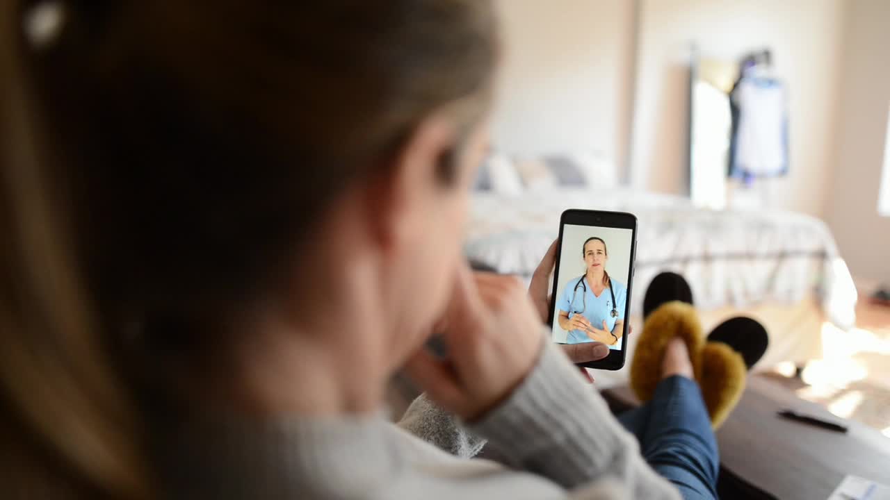 一个女人在家里用智能手机应用跟她的医生聊天视频素材