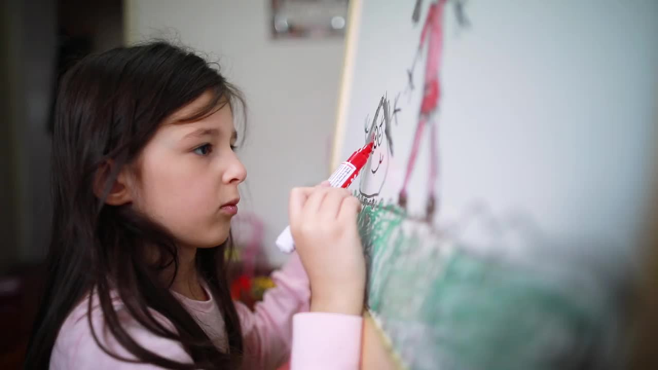 女孩在家里的白板上画画，表达她的创造力视频素材