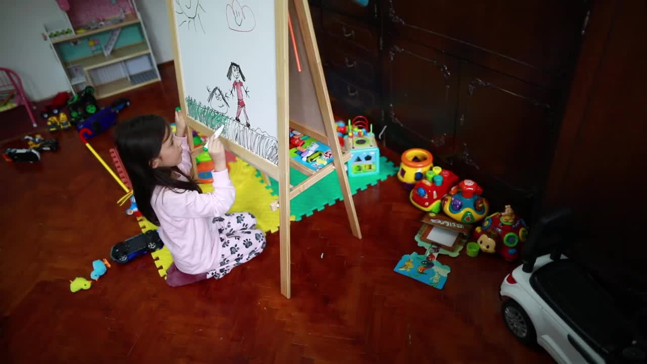 小女孩一大早就在白板上画画视频素材