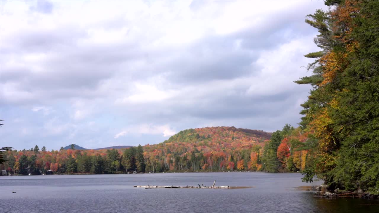 时间流逝-云飞过湖周围的秋天颜色的树木在佛蒙特州视频素材