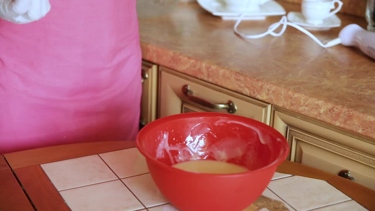 糕点师用搅拌机搅拌粉色蛋糕糖霜。视频素材