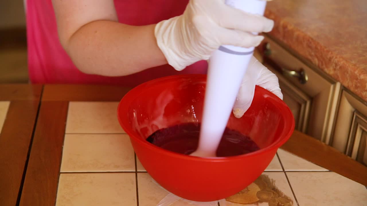 糕点师用搅拌机搅拌粉色蛋糕糖霜。视频素材