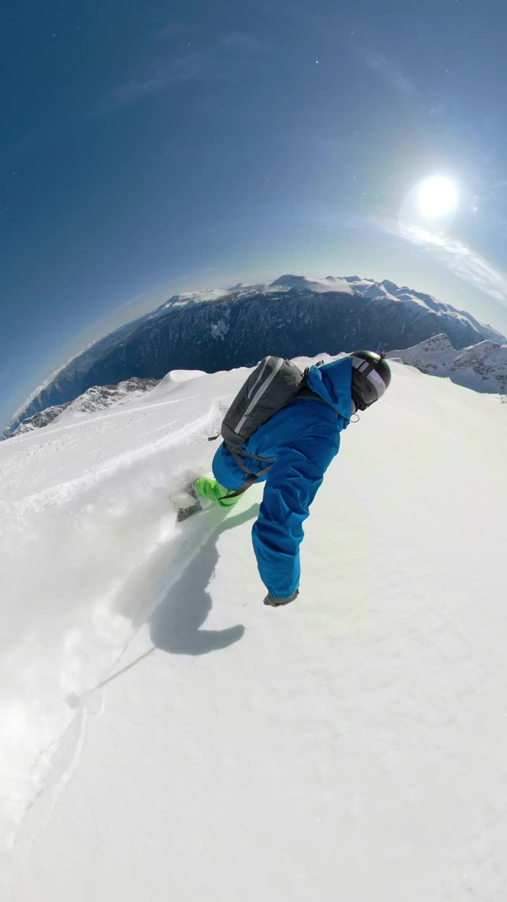 垂直:在阳光明媚的日子里，一名不知名的免费滑雪者雕刻着新鲜的粉末。视频素材