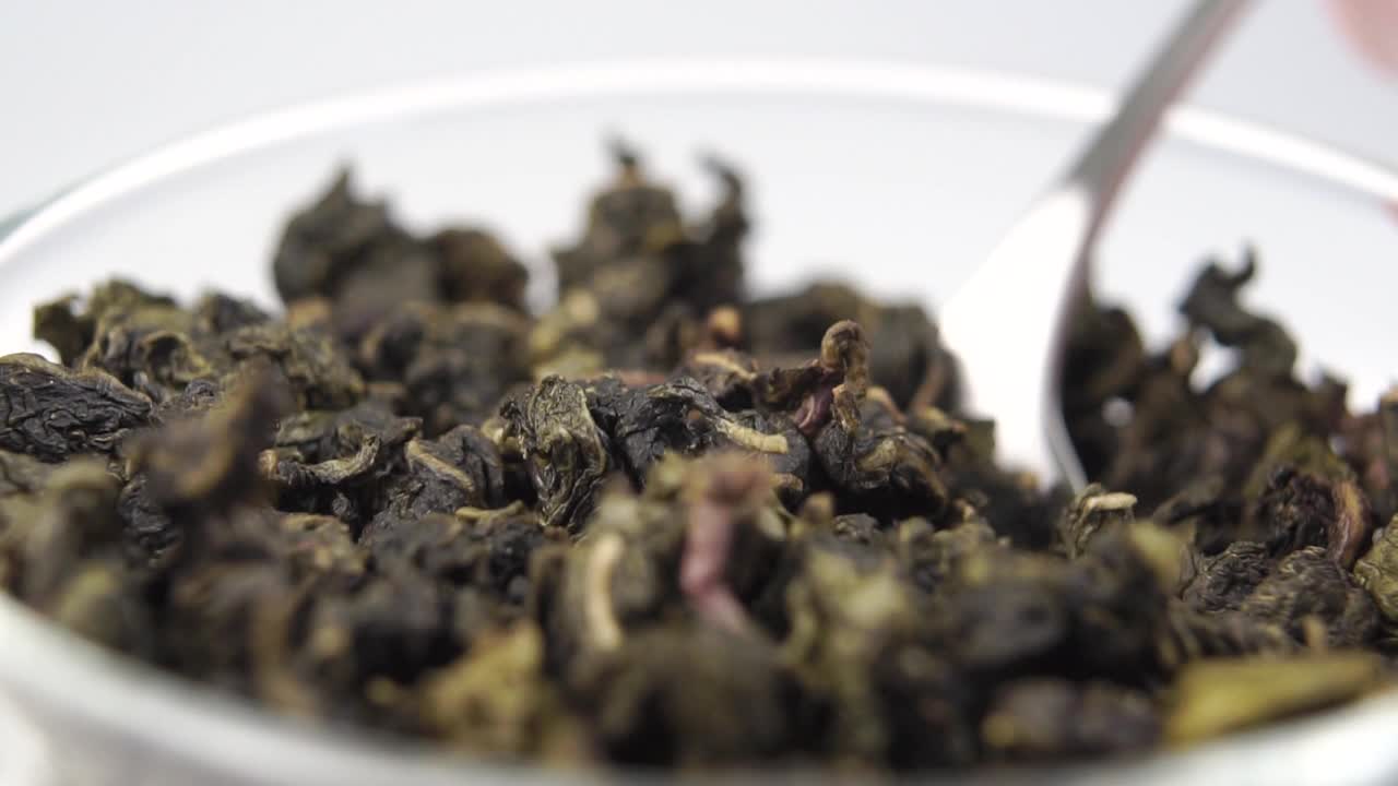 将拧干的绿茶叶放在茶匙中特写视频下载