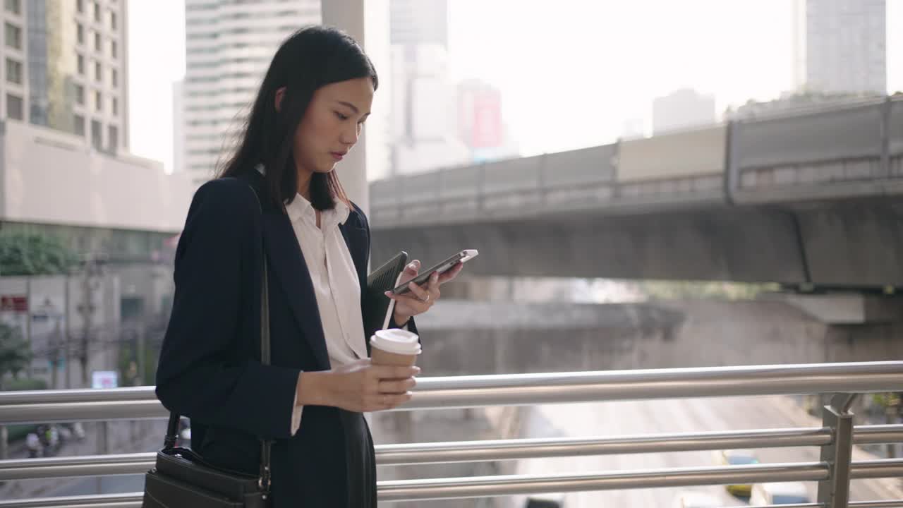 女商人走路时使用智能手机视频素材