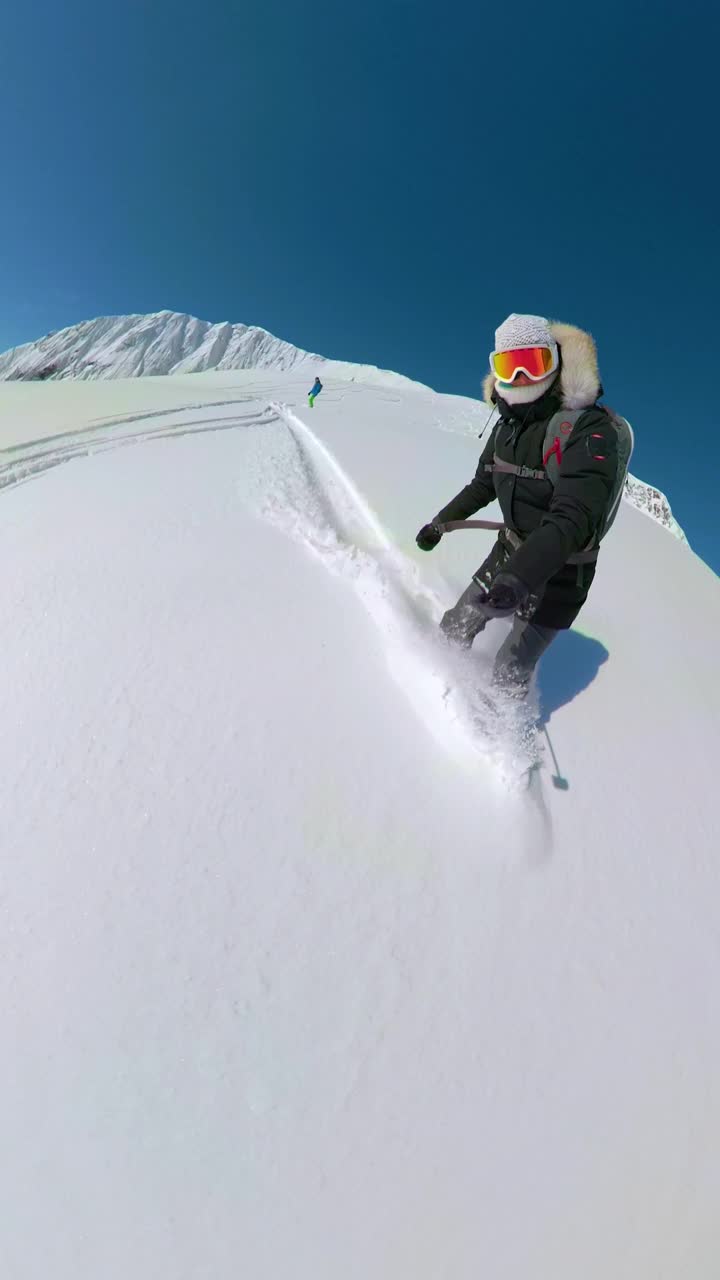垂直:斯托克滑雪板女孩雕刻在阳光明媚的高山小径。视频素材