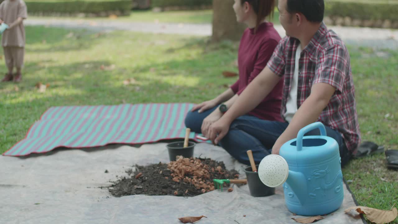 一家人教他们的两个儿子如何用厨房和花园的废弃物制作有机肥料视频素材