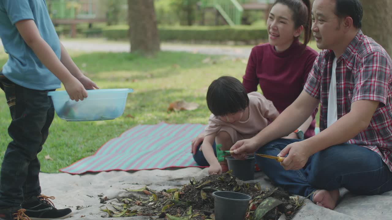 一家人教他们的两个儿子如何用厨房和花园的废弃物制作有机肥料视频下载
