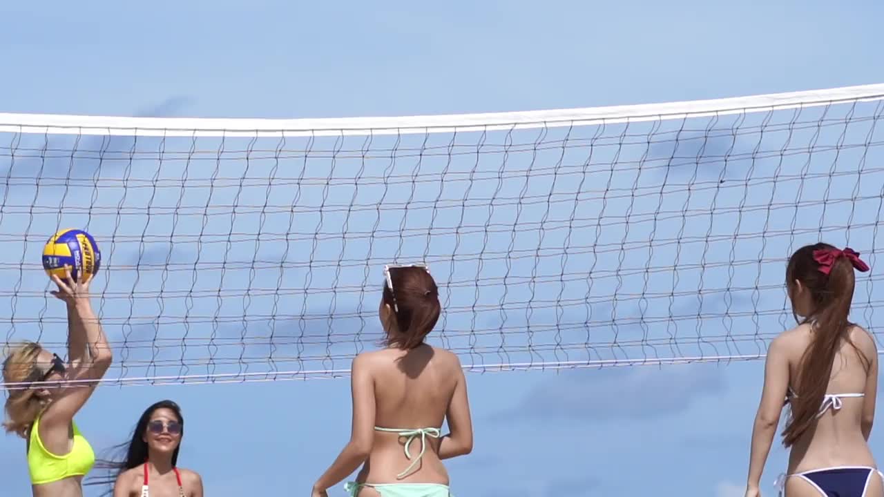 一群朋友在打沙滩排球。视频下载
