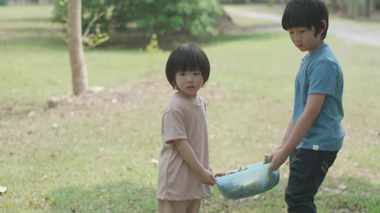 两个男孩用厨房和花园的废弃物做有机肥料视频素材