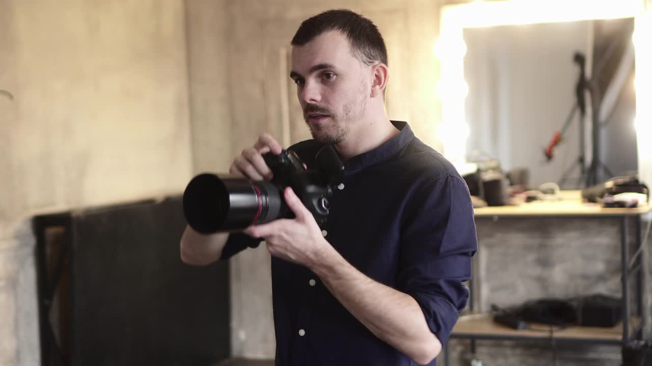 一个年轻的男摄影师正在工作室里给模特拍照。视频素材
