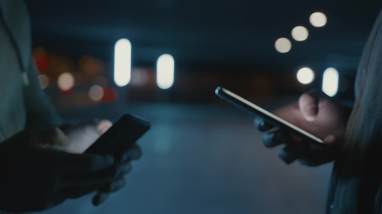 SLO MO蒙面男子在晚上使用智能手机视频下载