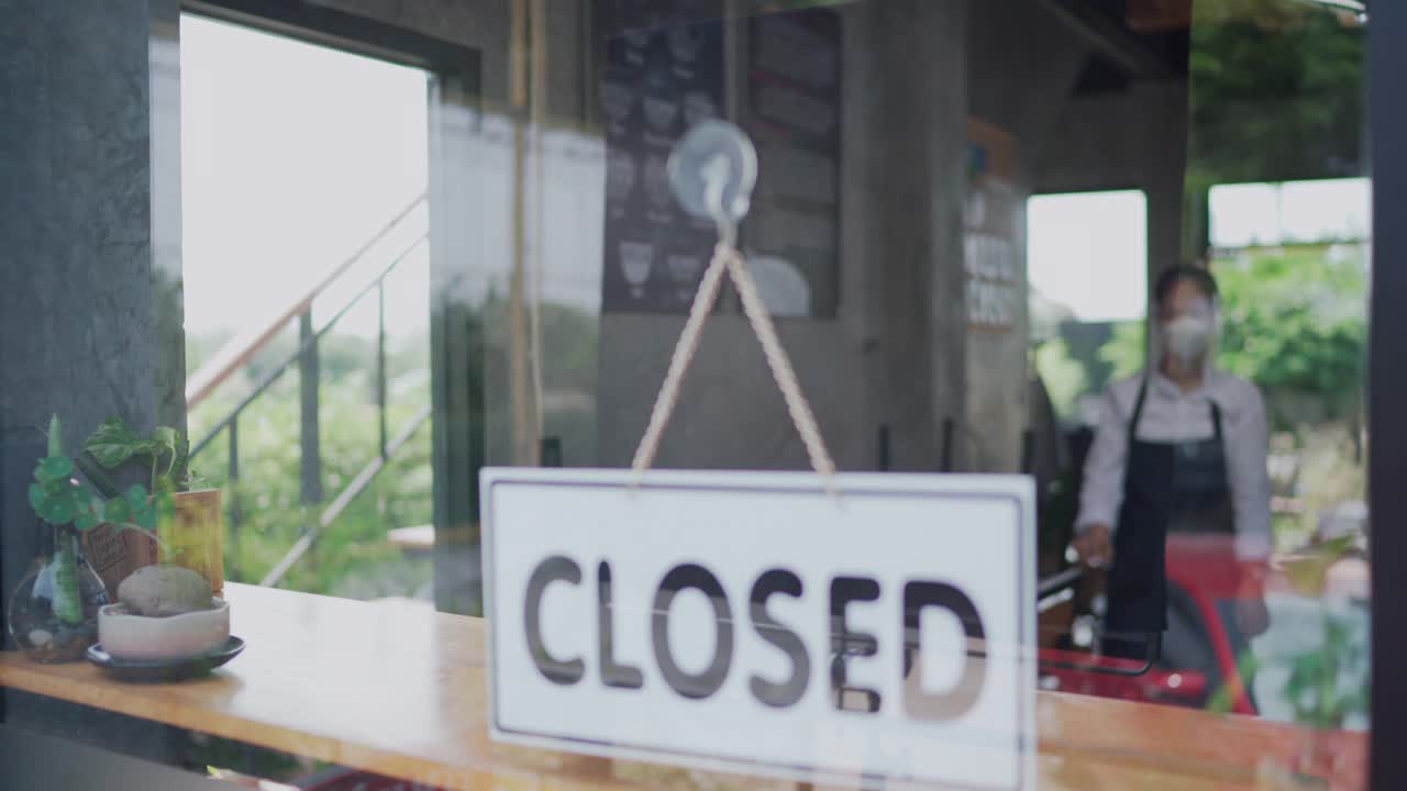 年轻的亚洲夫妇新企业主翻转开放的标志在咖啡店视频素材