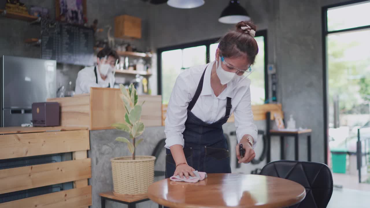 亚洲夫妇的企业主清理咖啡店准备重新开业视频素材