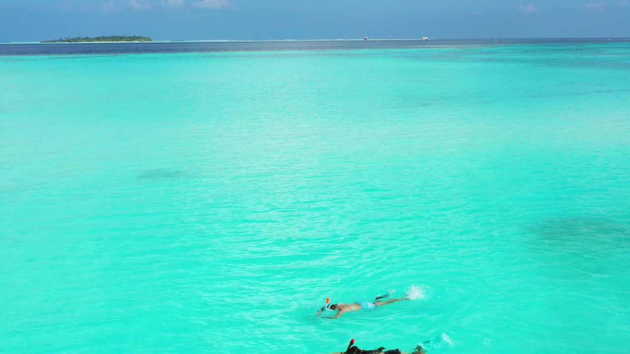 一对年轻夫妇在阳光明媚的热带天堂浮潜视频下载