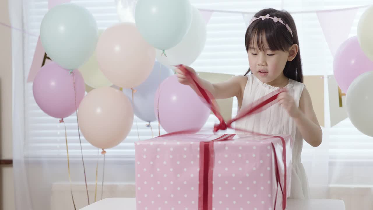 蹒跚学步的小女孩正在打开她的生日礼物盒视频下载