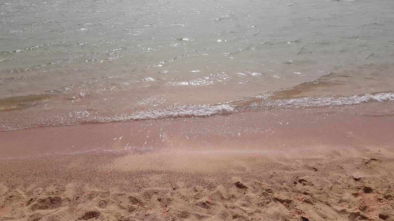 柔软透明的海浪在沙滩上。视频下载