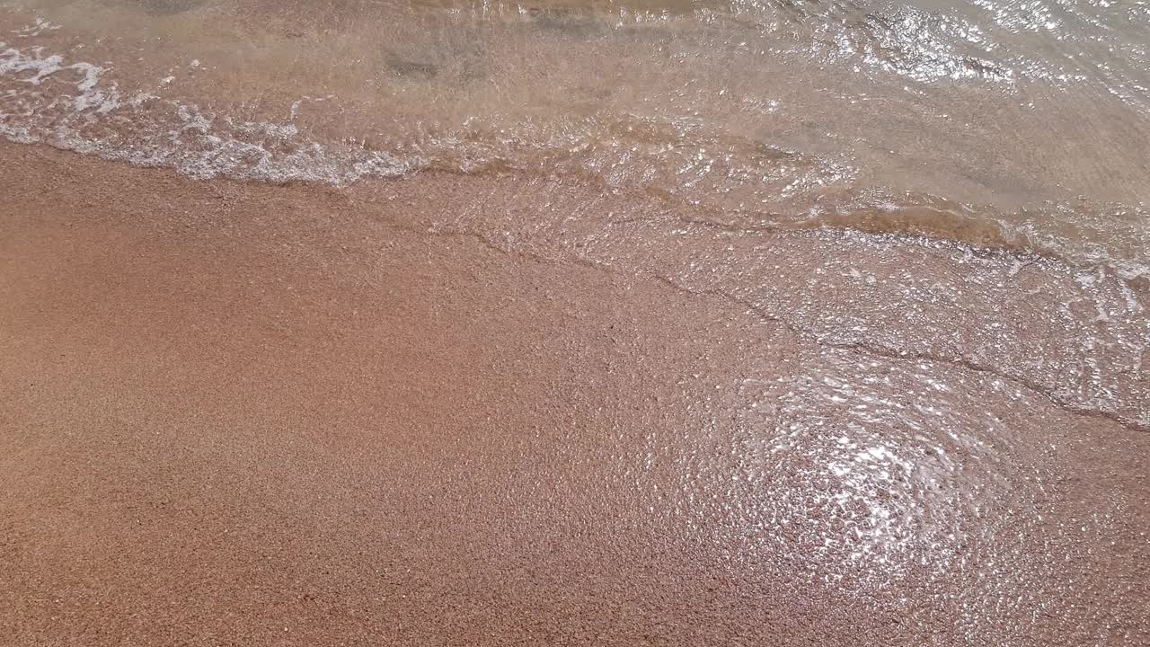 柔软透明的海浪在沙滩上。视频素材