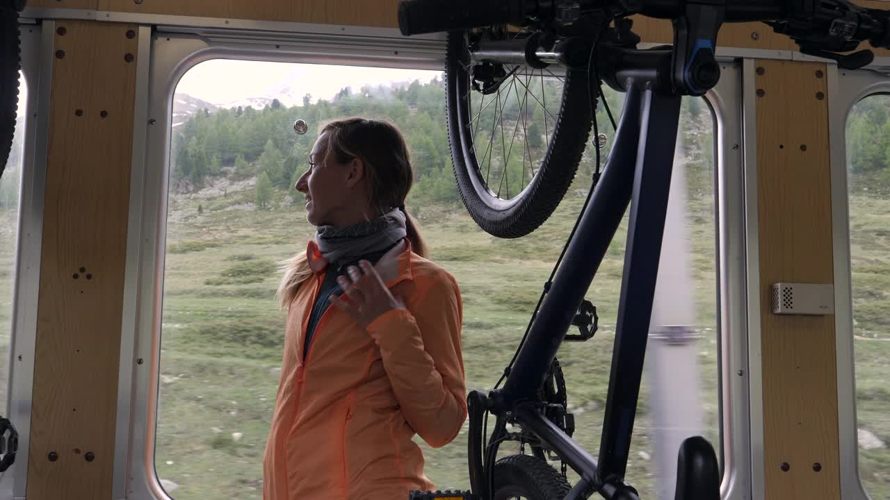 山地摩托车手乘火车旅行。女性在火车车厢里背着自行车视频下载