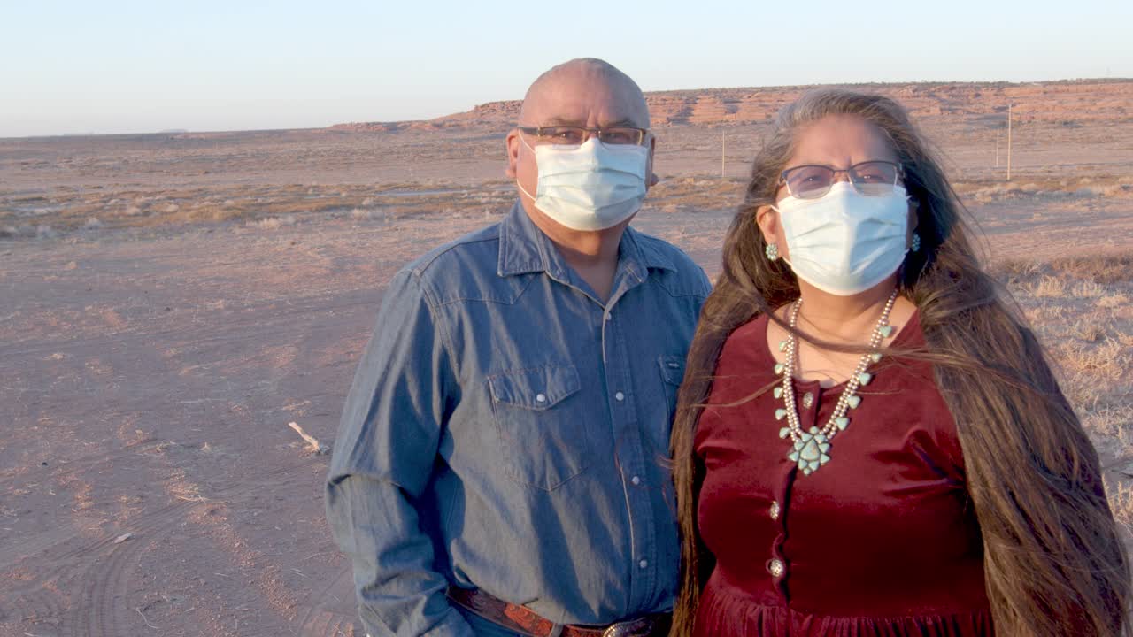 美国原住民夫妇在犹他州纪念碑谷的家附近戴着保护面罩，视频剪辑视频素材