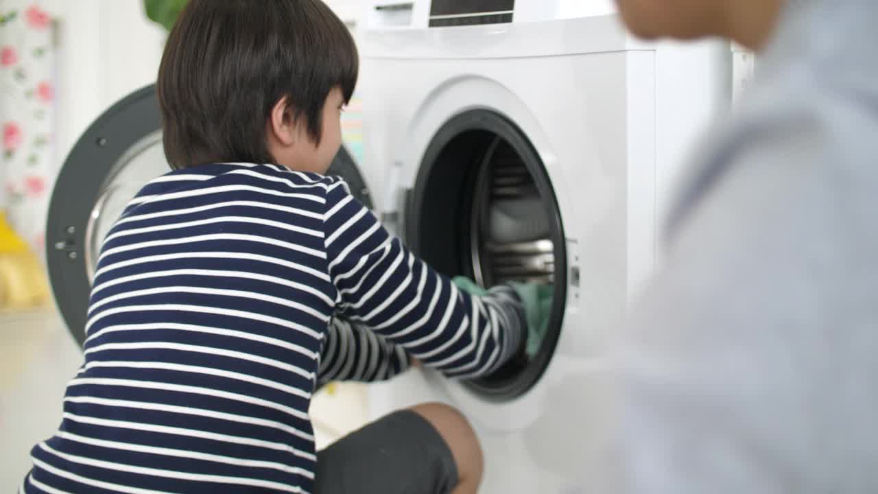 儿子在家帮父亲洗衣服，家庭家务团聚观念视频素材