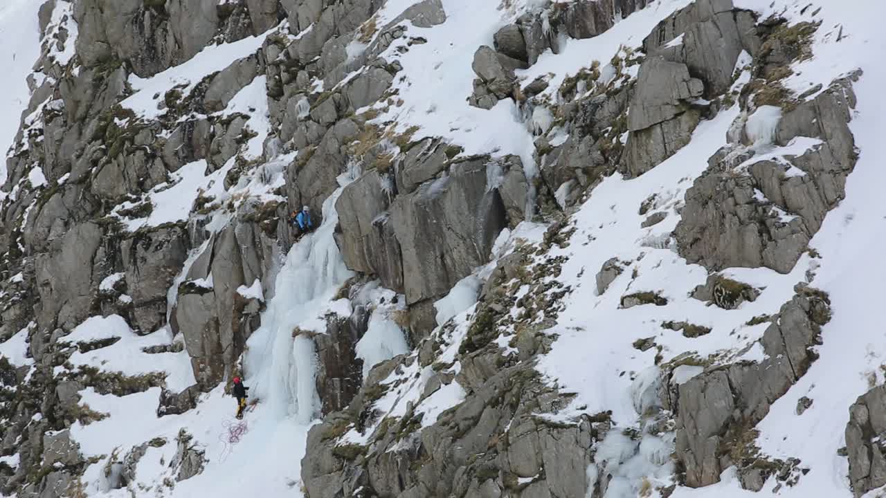 在英国湖区科尼斯顿老人的斜坡上，冬季，冰攀登者在低水贝克的冰瀑上冰冻。视频素材