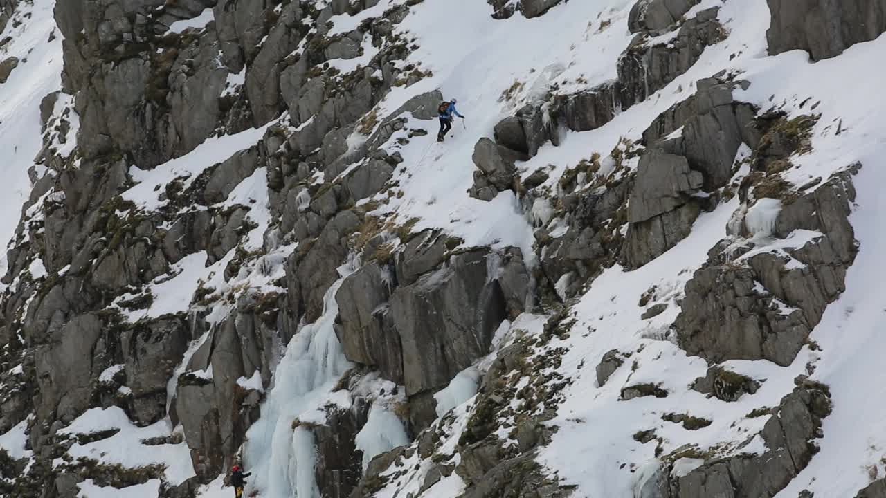 在英国湖区科尼斯顿老人的斜坡上，冬季，冰攀登者在低水贝克的冰瀑上冰冻。视频素材