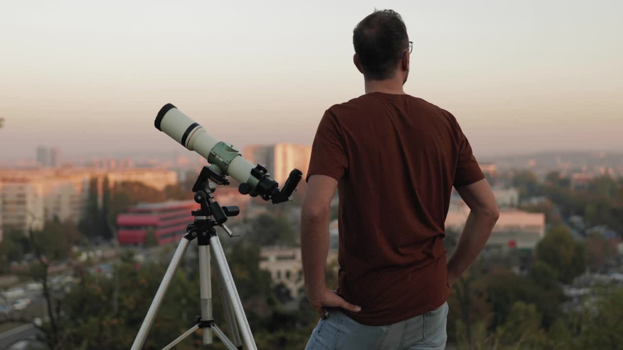 用望远镜看天空的业余天文学家。视频下载
