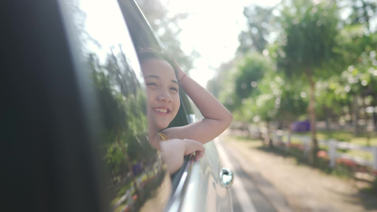 快乐的亚洲小女孩享受和父母在汽车上的公路旅行假期。视频素材