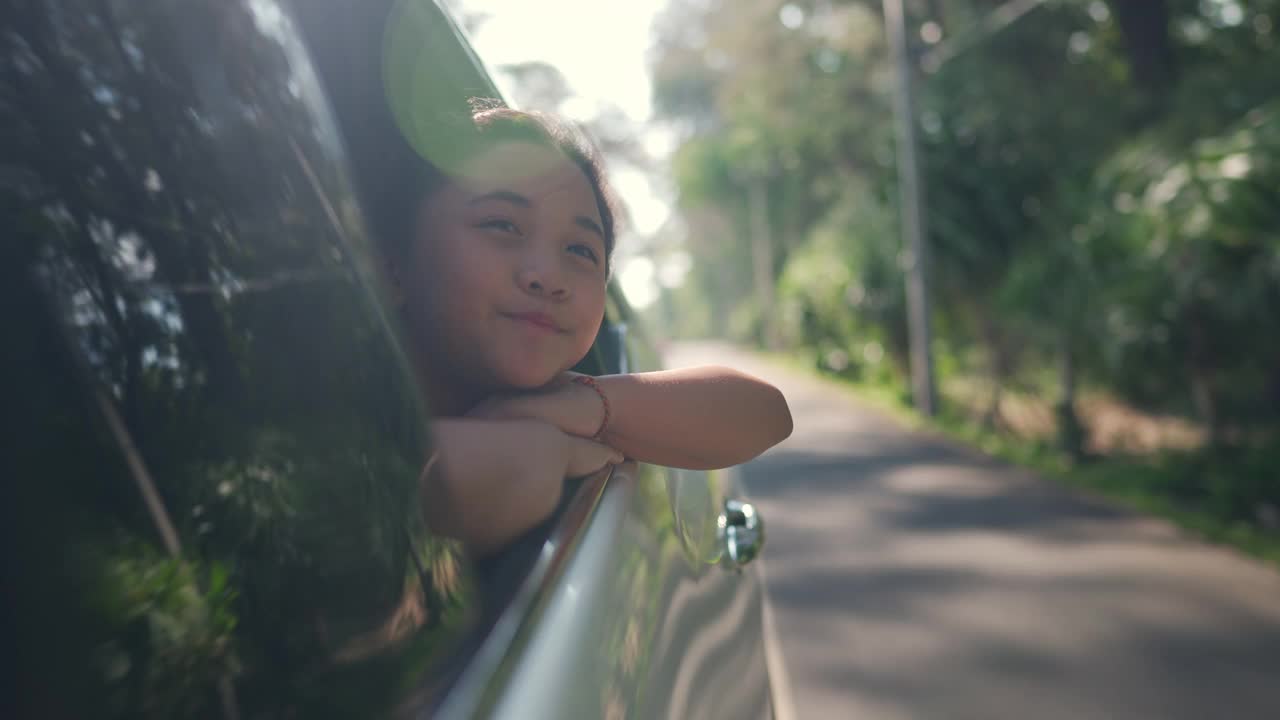 快乐的亚洲小女孩享受和父母在汽车上的公路旅行假期。视频下载