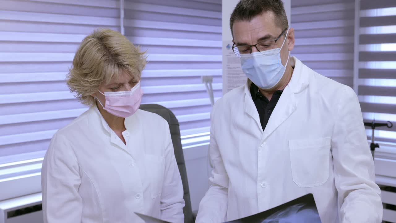 医生戴着防护口罩，检查x光慢动作视频素材