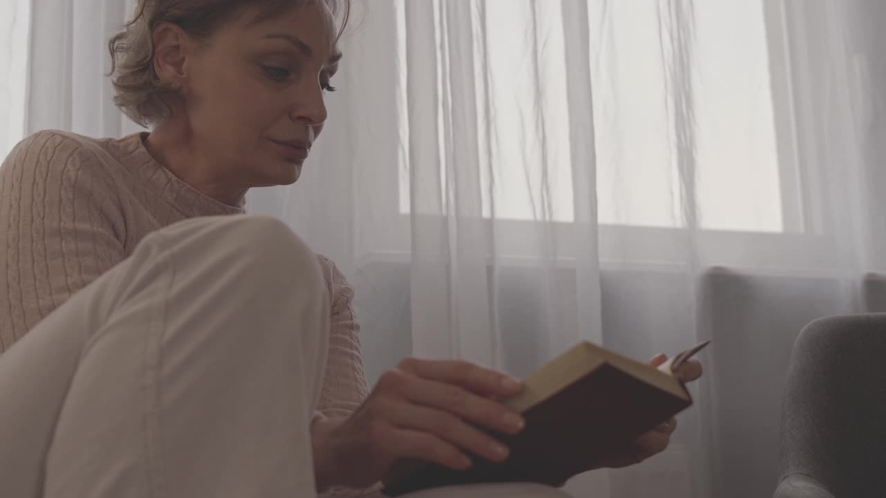 女人微笑着读一本有趣的书视频素材
