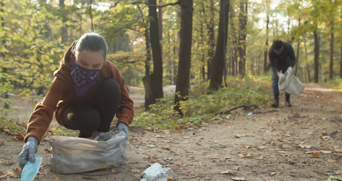 志愿者戴上防护面罩，从口罩和塑料中清洁自然视频下载