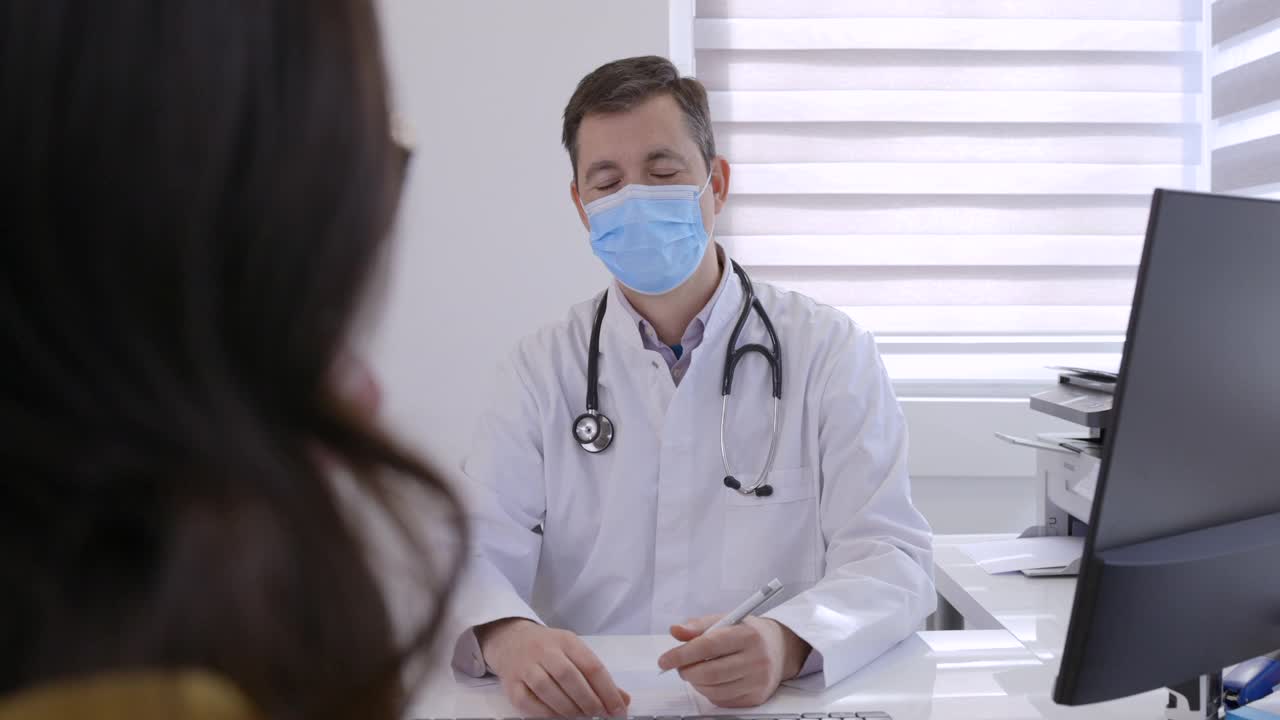 医生微笑着保护面罩给女病人开处方视频下载