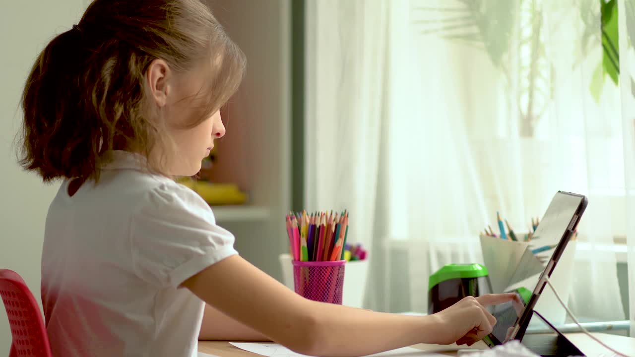 可爱的孩子使用笔记本电脑进行教育，在线学习，在家学习。女孩有家庭作业在家上学。视频素材