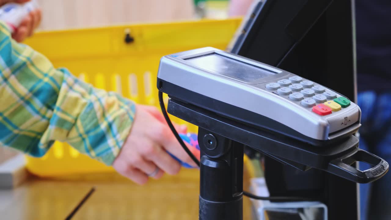 超市:收银台顾客用智能手机支付他的食物视频素材
