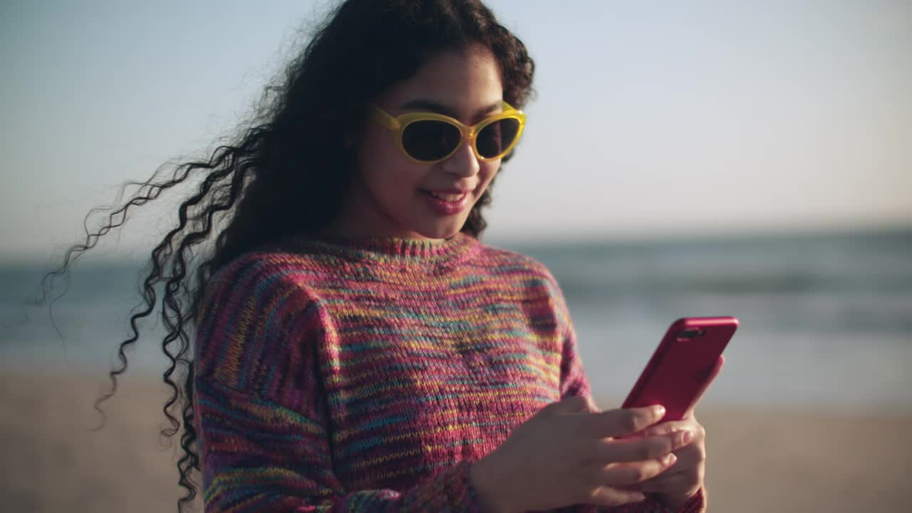 年轻女子在沙滩上视频通话视频素材