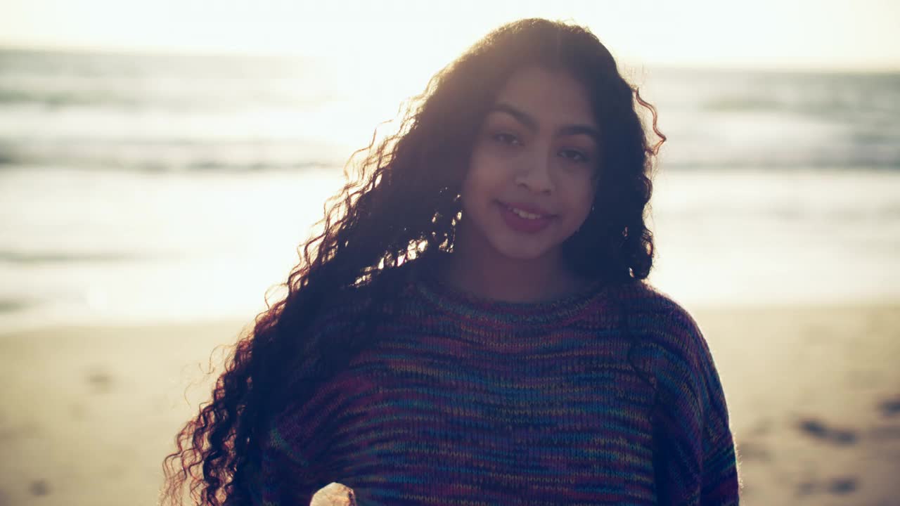 一名年轻的拉丁裔女子站在海滩上微笑视频下载