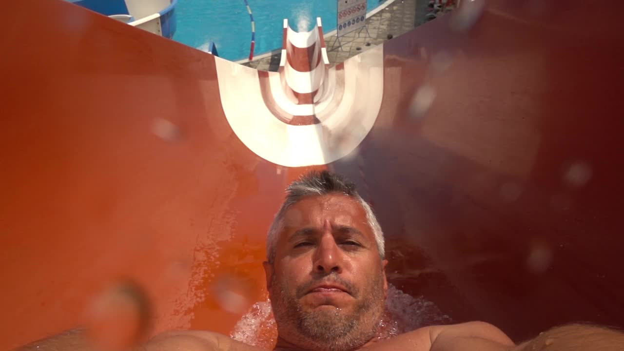 在避暑胜地玩水滑梯的男人视频下载