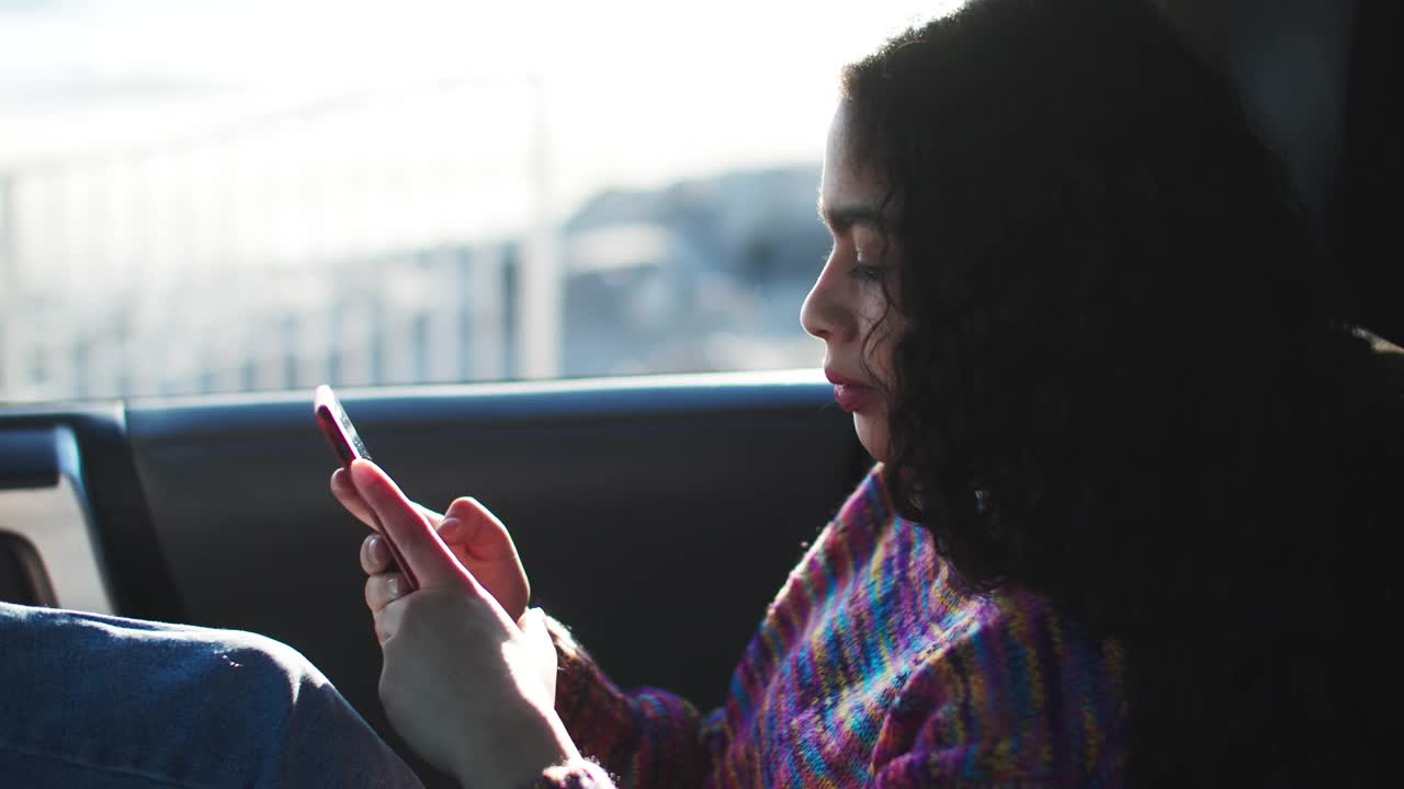一名年轻女子在车里等车的时候用手机视频素材