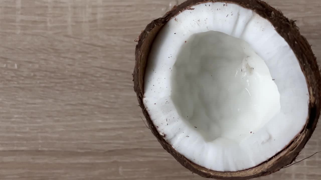 椰子汁从破碎的椰子汁流出的慢动作视频。视频素材