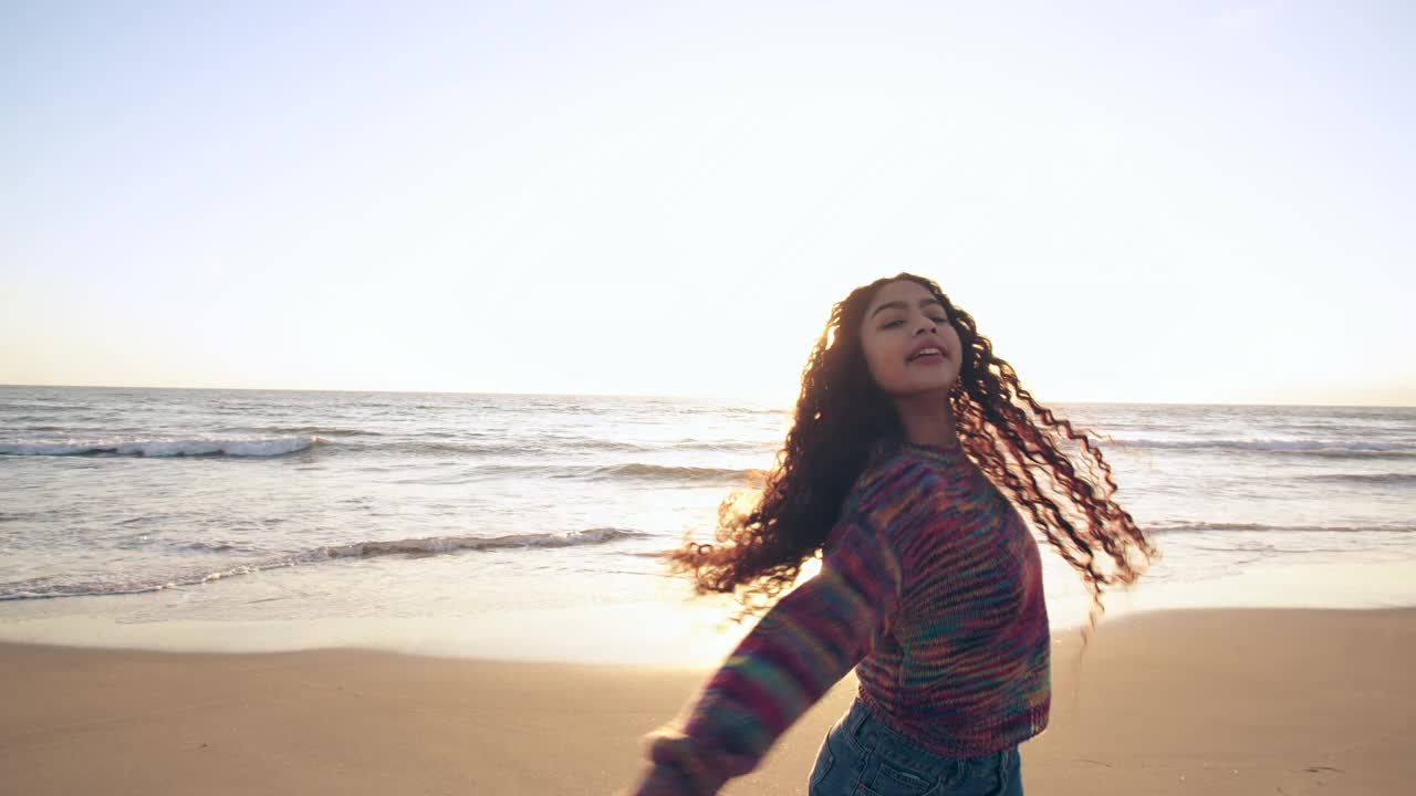 日落时分，年轻女子在海滩上跳舞视频下载