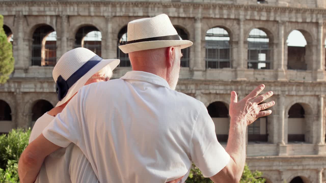 一家老年人在罗马度假。一对老夫妇站在斗兽场附近四处张望视频素材