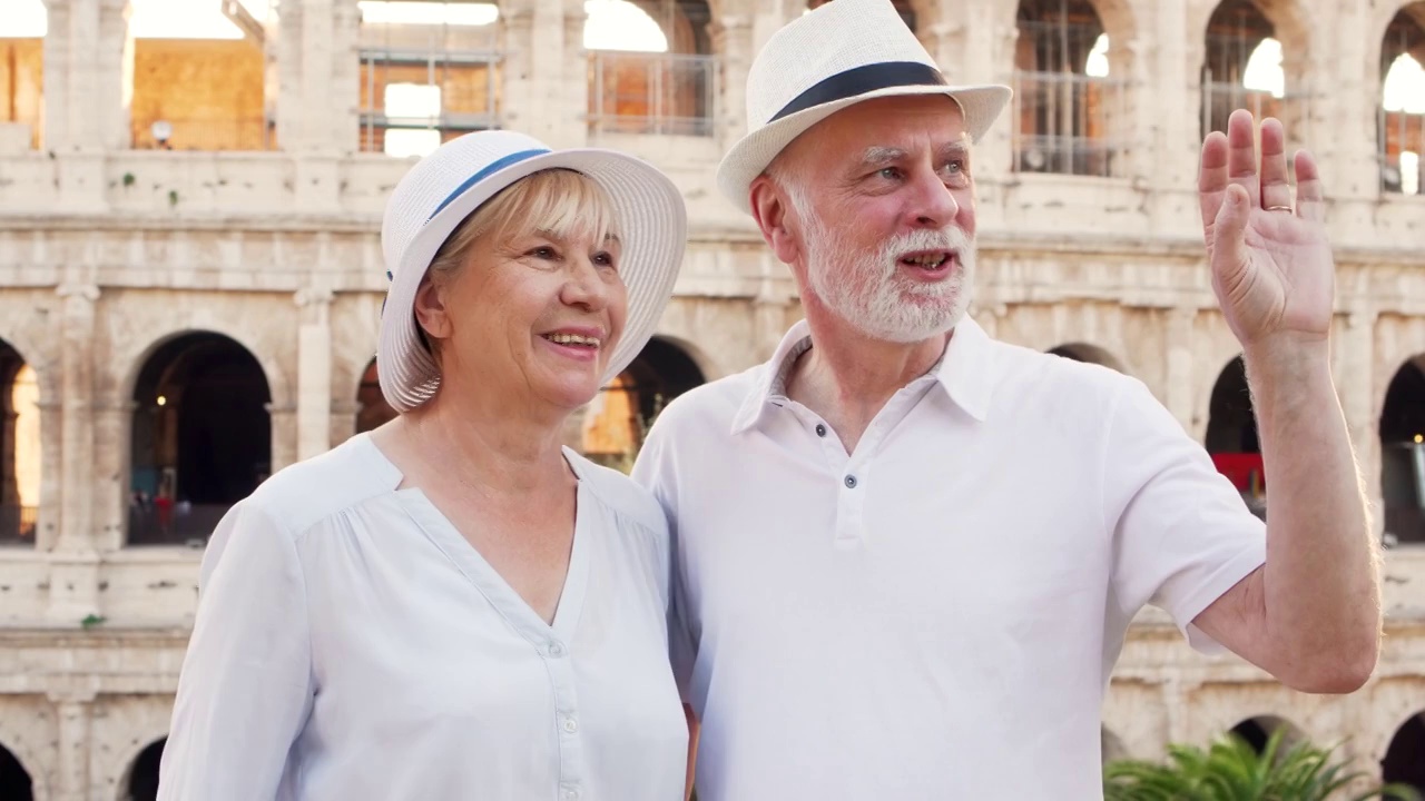 一家老年人在罗马度假。一对老夫妇站在斗兽场附近四处张望视频素材